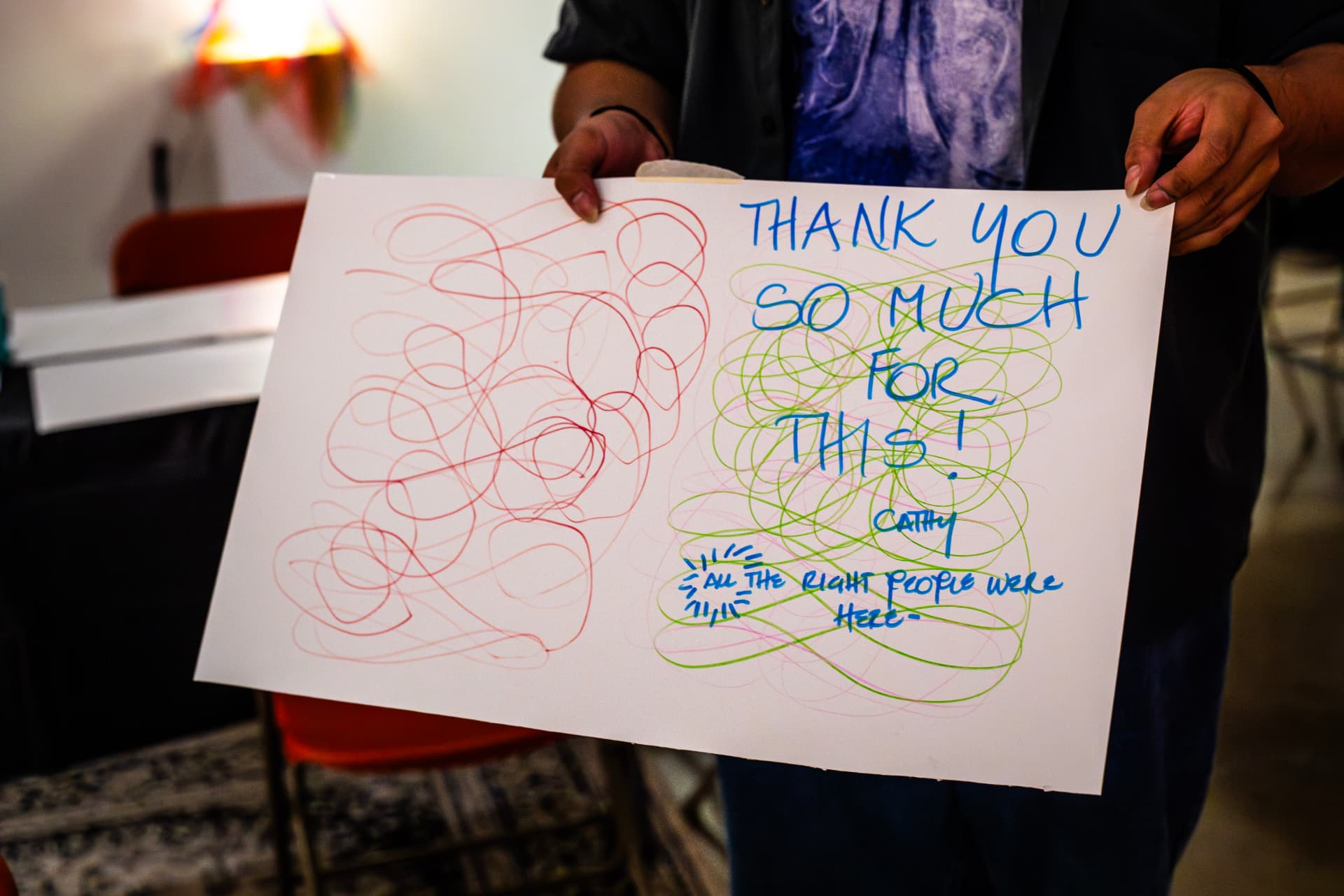 A participant holding up a hand-drawn thank you note made during a Second Wind & Co. session