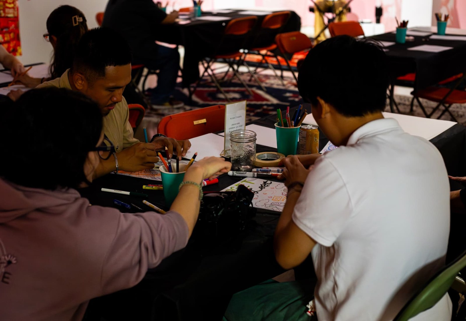Participants drawing together at a shared table during a Second Wind & Co. session