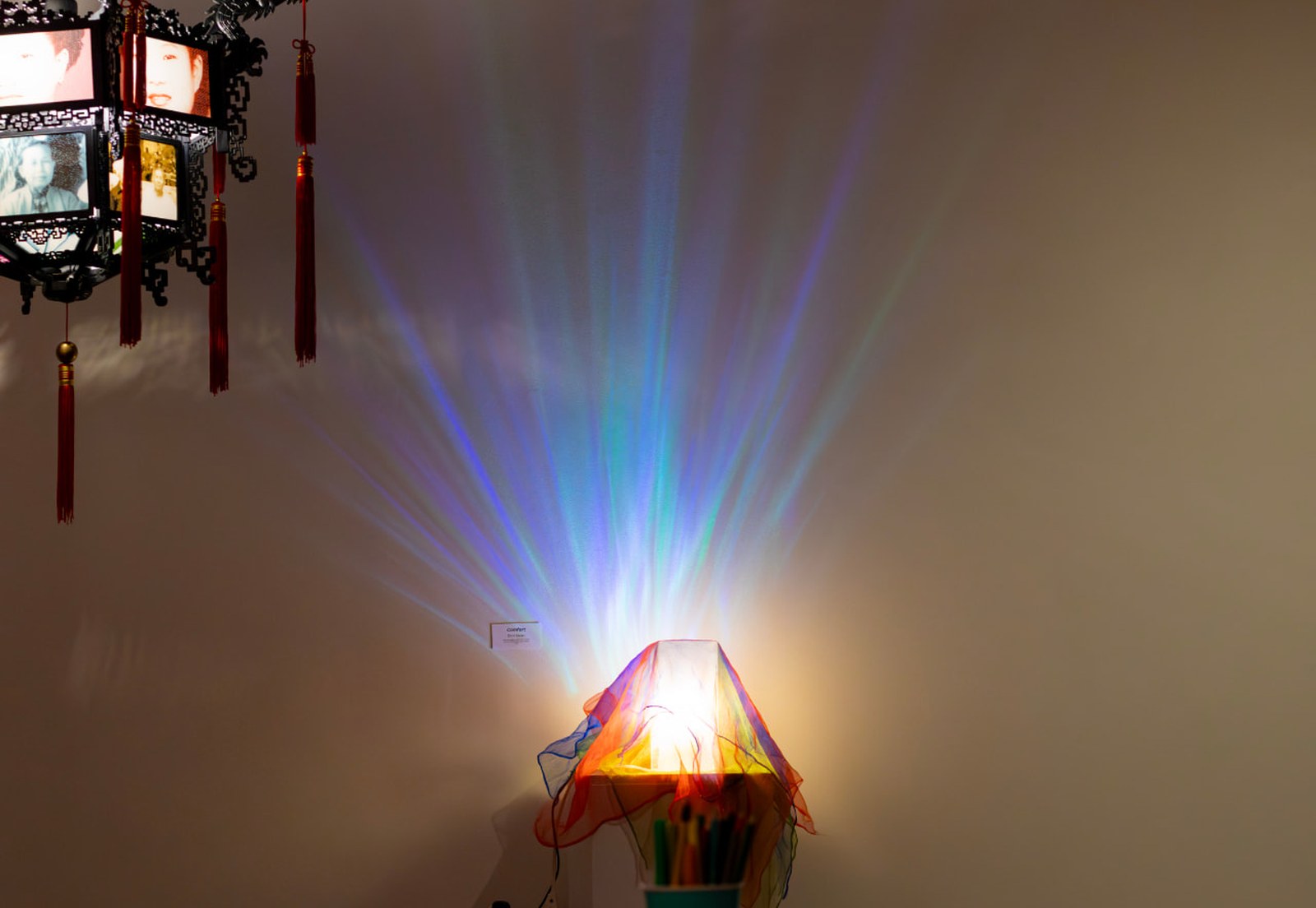 A softly lit lamp casting coloured light across a quiet room